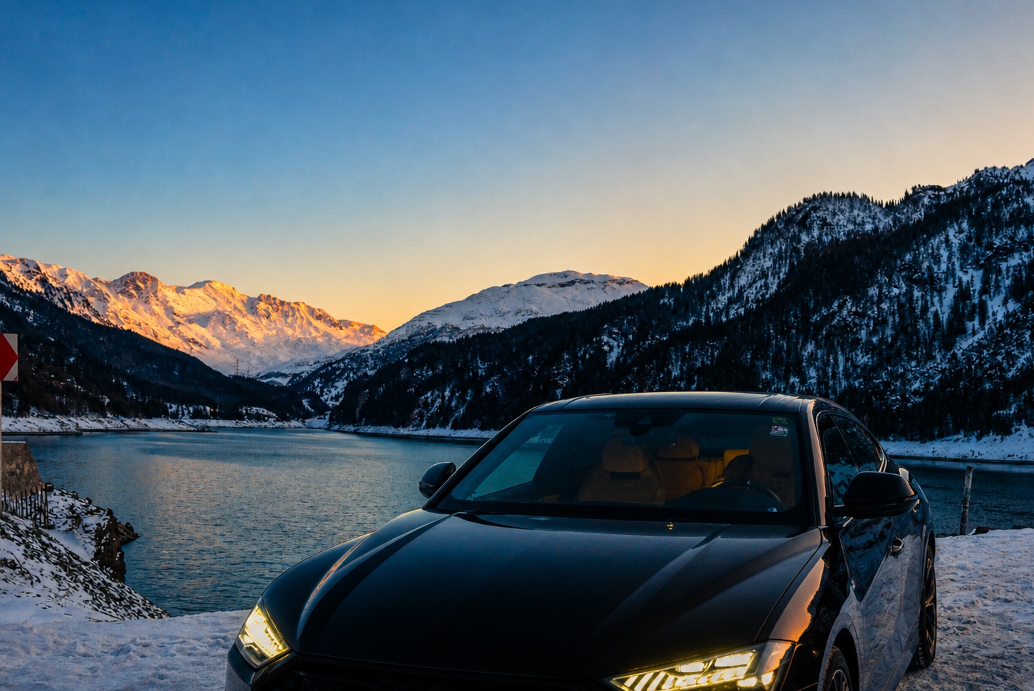 Luxury car by an Alpine lake at sunset